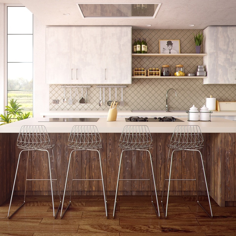 Modern kitchen with wooden floors and wire bar stools.